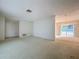 Spacious living room with carpet floors and an open layout that leads to the outside patio at 13725 Oak Forest N Blvd, Seminole, FL 33776