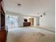 Spacious living room featuring an entertainment center, access to the patio, and an open kitchen layout at 13725 Oak Forest N Blvd, Seminole, FL 33776