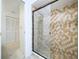 Tiled shower with glass doors and decorative pelican design, next to the closet at 13725 Oak Forest N Blvd, Seminole, FL 33776