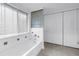 Well-lit bathroom features a tub with tile surround, a window with blinds, and a closet at 13898 Egret Ln, Clearwater, FL 33762