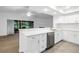 Bright kitchen features stainless appliances, white cabinetry, and eat-in breakfast bar at 13898 Egret Ln, Clearwater, FL 33762