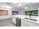 This kitchen features a stainless steel sink and appliances with white cabinets and countertops at 13898 Egret Ln, Clearwater, FL 33762