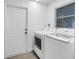 Convenient laundry room featuring modern, high-efficiency washer and dryer units against clean, white walls at 13898 Egret Ln, Clearwater, FL 33762
