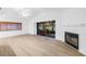 Bright living room with wood floors and fireplace, leading to screened-in porch at 13898 Egret Ln, Clearwater, FL 33762