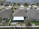 Aerial view of a property showing a well-maintained yard with a screened enclosure and lake views at 14015 Arbor Pines Dr, Riverview, FL 33579