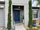 Elegant entryway with a stylish blue door and manicured greenery at 14015 Arbor Pines Dr, Riverview, FL 33579