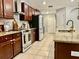 Modern kitchen with granite countertops, brown cabinets, and updated appliances at 14015 Arbor Pines Dr, Riverview, FL 33579