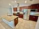A kitchen featuring stainless steel appliances, granite countertops, an island with a sink, and tiled floors at 14015 Arbor Pines Dr, Riverview, FL 33579