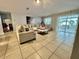 Bright living room featuring neutral furniture, tiled floors, and sliding glass doors to the outside at 14015 Arbor Pines Dr, Riverview, FL 33579