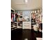 Spacious walk-in closet with ample storage, custom shelving and dark floors at 14015 Arbor Pines Dr, Riverview, FL 33579