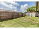 Backyard with green grass, a wooden fence, and a storage shed at 16023 Splitlog Dr, Tampa, FL 33618