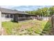 View of the backyard and screened-in patio, leading to the green lawn at 16023 Splitlog Dr, Tampa, FL 33618