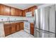 Kitchen featuring stainless steel appliances, tiled floors and wood cabinets at 16023 Splitlog Dr, Tampa, FL 33618