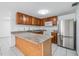 Kitchen with island featuring stainless steel appliances, tiled floors and wood cabinets at 16023 Splitlog Dr, Tampa, FL 33618