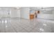 Large living room with tiled floors and white walls, open to the dining area and kitchen at 16023 Splitlog Dr, Tampa, FL 33618