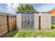 View of a backyard storage shed next to a wooden fence and some sparse vegetation at 16023 Splitlog Dr, Tampa, FL 33618