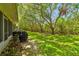 Lush green backyard featuring a volleyball net shaded by mature trees, great for outdoor activities at 1676 Arabian Ln, Palm Harbor, FL 34685