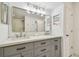 Bright bathroom featuring a double sink vanity with gray cabinetry and modern lighting at 1676 Arabian Ln, Palm Harbor, FL 34685