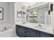 Bathroom featuring a dual-sink vanity with shower tub combo with tiled walls at 1676 Arabian Ln, Palm Harbor, FL 34685
