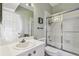 Bathroom featuring a shower-tub combo with sliding glass doors and white vanity at 1676 Arabian Ln, Palm Harbor, FL 34685