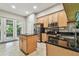 Well-appointed kitchen with black countertops, stainless steel appliances, and center island at 1676 Arabian Ln, Palm Harbor, FL 34685