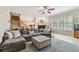 Bright living room featuring a large sectional sofa, fireplace, plantation shutters and staircase at 1676 Arabian Ln, Palm Harbor, FL 34685