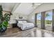 Bright primary bedroom featuring a large bed, vaulted ceilings, and arched windows with sheer curtains at 1676 Arabian Ln, Palm Harbor, FL 34685