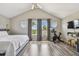 Bright primary bedroom featuring a large bed, vaulted ceilings, arched windows and an exercise bike at 1676 Arabian Ln, Palm Harbor, FL 34685