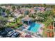 Community pool with lounge chairs, tables, and chairs surrounded by lush landscaping at 1676 Arabian Ln, Palm Harbor, FL 34685
