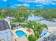 Stunning aerial view of the property with a pool, landscaping, and lake view at 1807 Split Fork Dr, Oldsmar, FL 34677