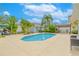 Lush backyard with a beautiful pool, mature trees, and a pergola, perfect for outdoor entertaining at 1807 Split Fork Dr, Oldsmar, FL 34677
