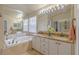 Bathroom with a soaking tub, double vanity, granite countertops, and updated fixtures at 1807 Split Fork Dr, Oldsmar, FL 34677