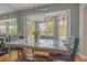 Bright dining area showcasing a modern chandelier, hardwood floors, and a window seat with backyard views at 1807 Split Fork Dr, Oldsmar, FL 34677