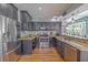 Galley kitchen boasting granite countertops, stainless steel appliances, dark cabinetry and hardwood floors at 1807 Split Fork Dr, Oldsmar, FL 34677