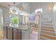 Open concept living room with vaulted ceiling, view of staircase, TV and Kitchen at 1807 Split Fork Dr, Oldsmar, FL 34677