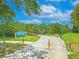 Harbor Palms Nature Park entrance featuring a paved path, signage, lush greenery, and a wooden bridge at 1807 Split Fork Dr, Oldsmar, FL 34677