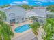 Aerial view of a private backyard oasis with a sparkling pool, covered patio, and lush landscaping at 1807 Split Fork Dr, Oldsmar, FL 34677
