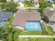 Aerial view of a home with a screened-in pool and a fenced-in backyard at 1838 Eagle Ridge Blvd, Palm Harbor, FL 34685