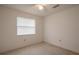 This carpeted bedroom features a ceiling fan and a window for natural light at 1838 Eagle Ridge Blvd, Palm Harbor, FL 34685