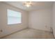 Bright bedroom features a window, ceiling fan, and neutral carpet at 1838 Eagle Ridge Blvd, Palm Harbor, FL 34685