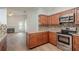 Charming kitchen features wood cabinets, stainless steel appliances, and a cozy, inviting atmosphere at 1838 Eagle Ridge Blvd, Palm Harbor, FL 34685