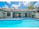 Sparkling blue pool surrounded by a screened enclosure and a lush backyard at 1838 Eagle Ridge Blvd, Palm Harbor, FL 34685