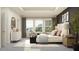 Relaxing main bedroom with a tray ceiling, neutral colors, and a seating area by the window at 18460 Serene Lake Loop, Lutz, FL 33548
