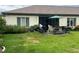 A cozy patio in a serene backyard setting with lush grass, a grill, and comfortable seating for relaxation at 18804 Tournament Trl, Tampa, FL 33647