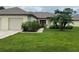 Charming home featuring a well-maintained lawn, lovely landscaping, and an attached two-car garage at 18804 Tournament Trl, Tampa, FL 33647