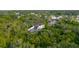 Aerial shot of a home with screened-in patio surrounded by lush green trees in residential area at 1974 Hidden Springs Pl, Clearwater, FL 33760