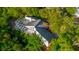 Backyard aerial view of home featuring a screened-in pool and luscious vegetation at 1974 Hidden Springs Pl, Clearwater, FL 33760