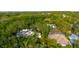 An aerial view of a home with a screened-in patio among dense trees and other homes at 1974 Hidden Springs Pl, Clearwater, FL 33760