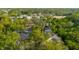 An aerial view of a home with screened-in patio surrounded by lush trees and a street at 1974 Hidden Springs Pl, Clearwater, FL 33760