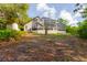 A hillside backyard with a large screened-in patio, mature trees, and a storage shed at 1974 Hidden Springs Pl, Clearwater, FL 33760